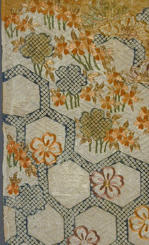 Vintage heirloom embroidered textile with delicate floral crewelwork on aged linen — antique hand-stitched piece preserved using dry conservation methods